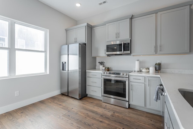 1621 Fagan St Unit 109, Chattanooga, TN 37408 - kitchen with stainless steel appliances, wood finished floors, gray cabinets, and recessed lighting