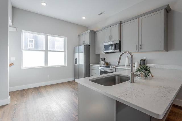 1621 Fagan St Unit 109, Chattanooga, TN 37408 - kitchen featuring stainless steel appliances, gray cabinets, recessed lighting, wood finished floors, and light stone counters