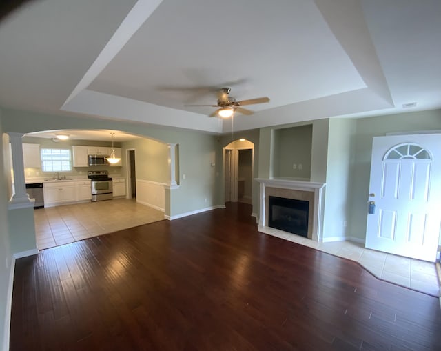 904 Cedar Creek Dr, Rossville, GA 30741 - unfurnished living room with a raised ceiling, a ceiling fan, light wood finished floors, and a fireplace with flush hearth