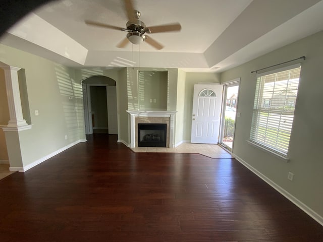 904 Cedar Creek Dr, Rossville, GA 30741 - unfurnished living room featuring a raised ceiling, a ceiling fan, wood finished floors, a fireplace, and arched walkways