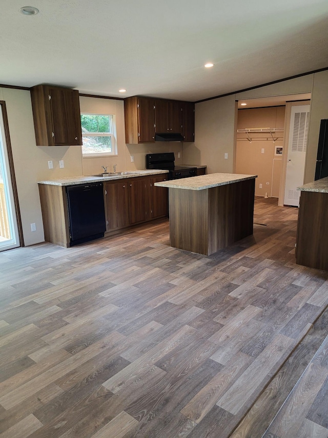 1918 Spradling Rd, Soddy Daisy, TN 37379 - kitchen featuring black appliances, wood finished floors, light countertops, under cabinet range hood, and a center island