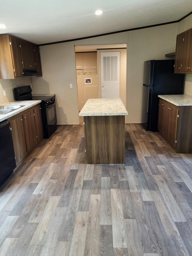 1918 Spradling Rd, Soddy Daisy, TN 37379 - kitchen featuring black appliances, under cabinet range hood, wood finished floors, a kitchen island, and dark brown cabinetry