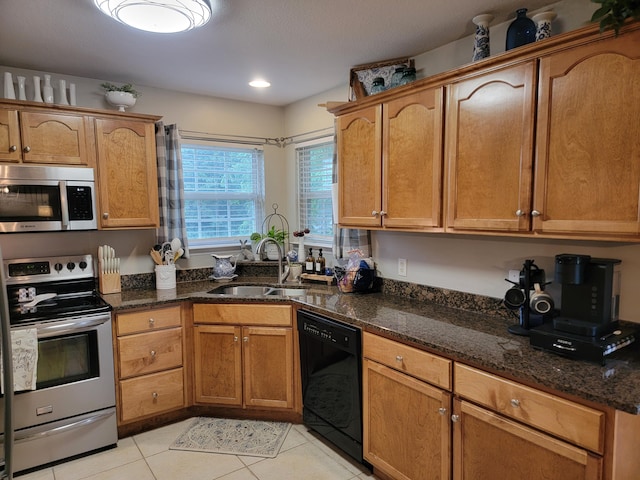 458 Fieldstone Dr, Ringgold, GA 30736 - kitchen featuring stainless steel appliances, light tile patterned flooring, dark stone counters, and brown cabinets