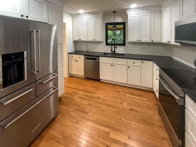 8127 Blue Spruce Dr, Hixson, TN 37343 - kitchen with stainless steel appliances, dark countertops, light wood finished floors, decorative backsplash, and recessed lighting