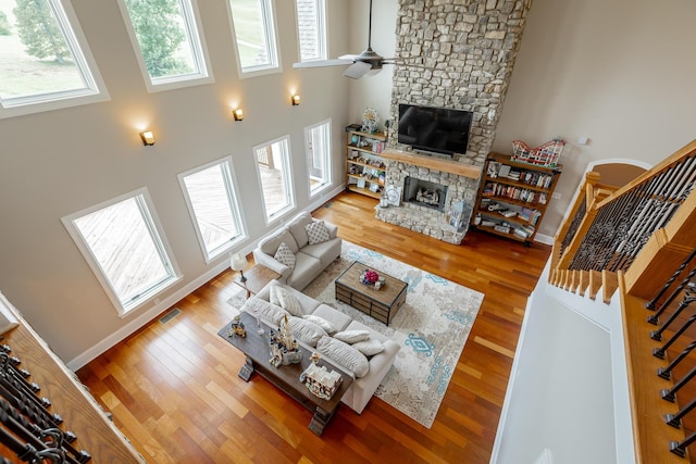 1524 Green Pond Rd, Soddy Daisy, TN 37379 - living area with a stone fireplace, ceiling fan, wood finished floors, stairs, and a high ceiling