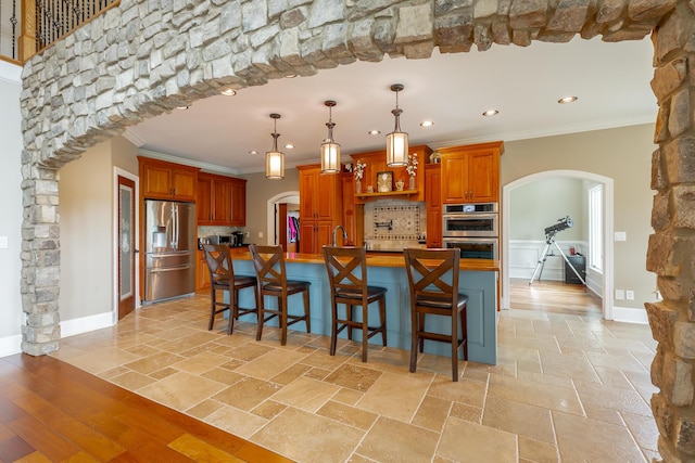 1524 Green Pond Rd, Soddy Daisy, TN 37379 - kitchen with arched walkways, appliances with stainless steel finishes, crown molding, recessed lighting, and brown cabinetry