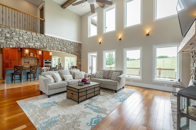 1524 Green Pond Rd, Soddy Daisy, TN 37379 - living room with a ceiling fan, light wood-style flooring, a towering ceiling, beamed ceiling, and arched walkways