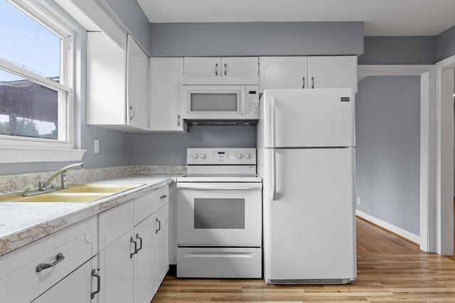 608 Maple Ln, Chattanooga, TN 37412 - kitchen with white appliances, light countertops, white cabinets, and light wood-type flooring