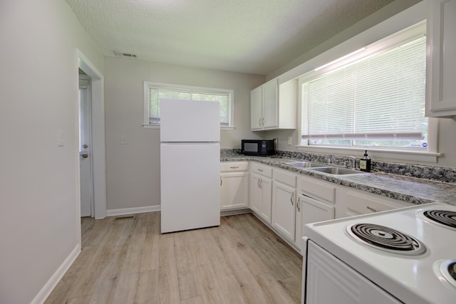 3011 Wilcox Blvd, Chattanooga, TN 37411 - kitchen featuring white appliances, light wood-style flooring, white cabinets, healthy amount of natural light, and a textured ceiling