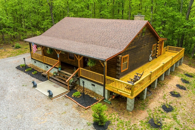 1590 Jackson Point Rd, Sewanee, TN 37375 - view of front of house with a view of trees, a chimney, roof with shingles, crawl space, and log siding