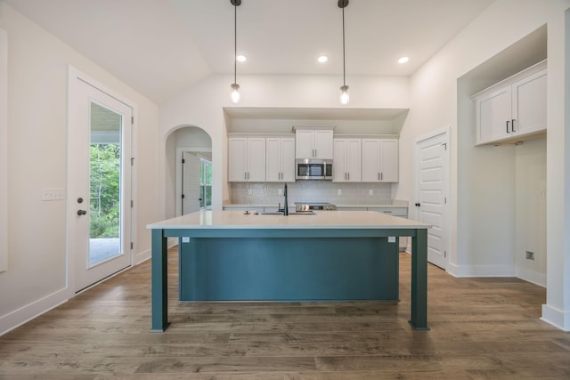 LOT3 Ari Ln, Chattanooga, TN 37421 - kitchen featuring stainless steel microwave, white cabinetry, decorative backsplash, arched walkways, and vaulted ceiling