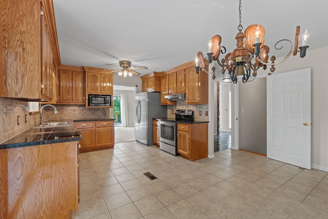 4838 Glenmar Cir, Chattanooga, TN 37416 - kitchen featuring stainless steel appliances, under cabinet range hood, decorative backsplash, and brown cabinets