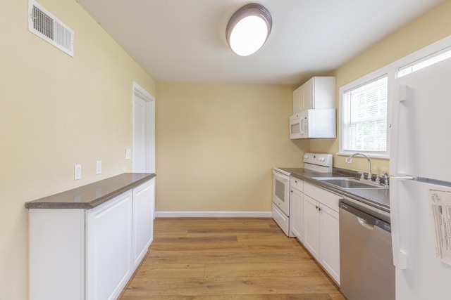 129 N Moore Rd, Chattanooga, TN 37411 - kitchen with white appliances, dark countertops, white cabinets, and light wood-style flooring