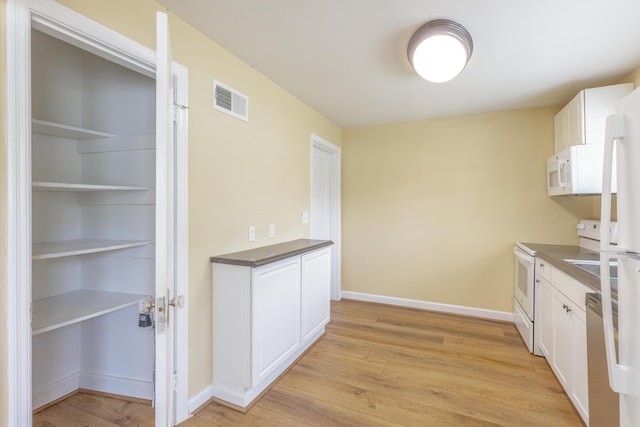 129 N Moore Rd, Chattanooga, TN 37411 - kitchen featuring white appliances, light wood-style flooring, white cabinets, and dark countertops