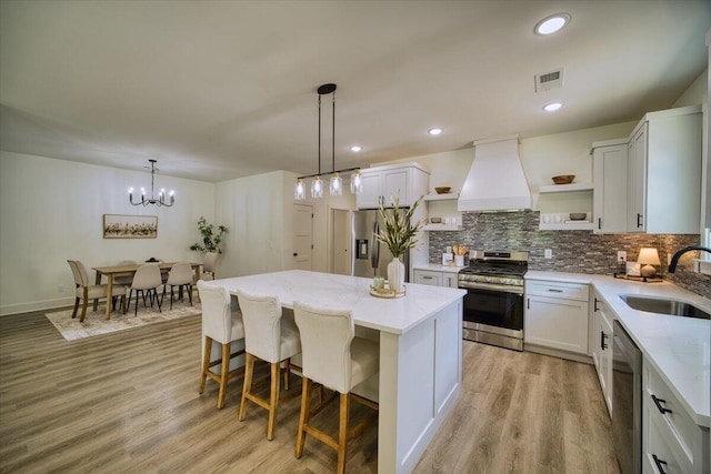824 Lower Mill Rd, Hixson, TN 37343 - kitchen featuring stainless steel appliances, open shelves, custom exhaust hood, a kitchen island, and light wood-type flooring
