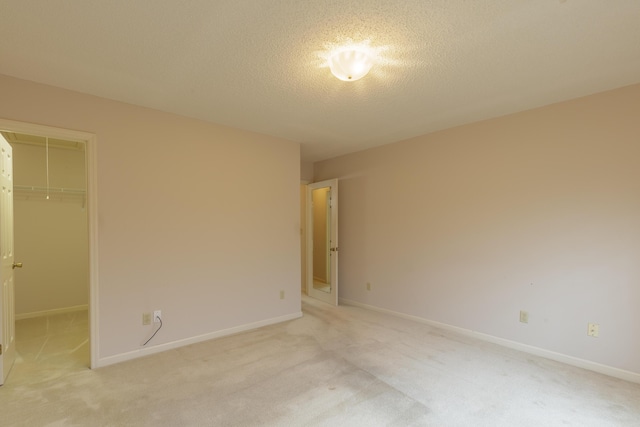 6580 Hickory Meadow Dr, Chattanooga, TN 37421 - unfurnished bedroom featuring light carpet, a walk in closet, a textured ceiling, and a closet