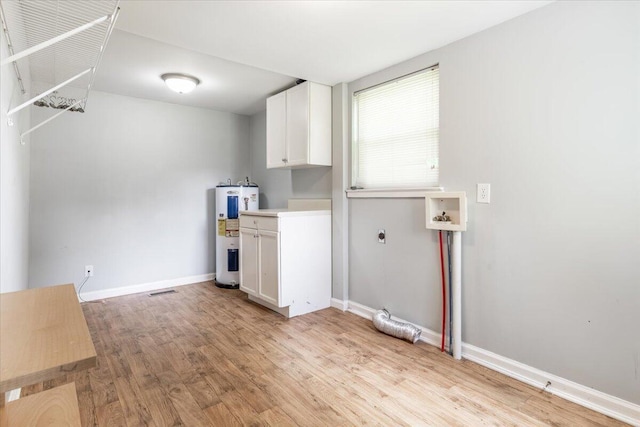 1 W 10th St, Chickamauga, GA 30707 - laundry room featuring electric water heater, cabinet space, light wood-type flooring, hookup for a washing machine, and hookup for an electric dryer