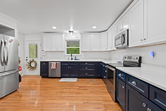 111 Oak Meadow Dr, Dunlap, TN 37327 - kitchen with stainless steel appliances, white cabinetry, light countertops, light wood-style flooring, and blue cabinets