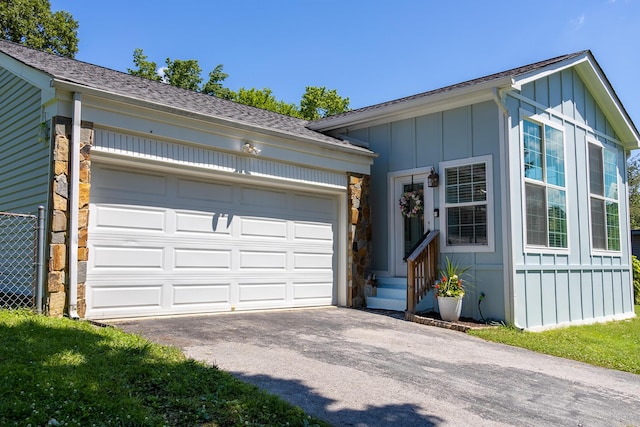 4619 Lake Haven Dr, Chattanooga, TN 37416 - view of front of home featuring board and batten siding, asphalt driveway, a garage, stone siding, and roof with shingles