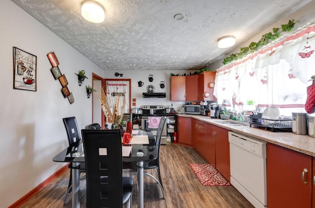 1339 Woodmore Ln, Chattanooga, TN 37411 - kitchen with appliances with stainless steel finishes, wood finished floors, light countertops, a textured ceiling, and under cabinet range hood
