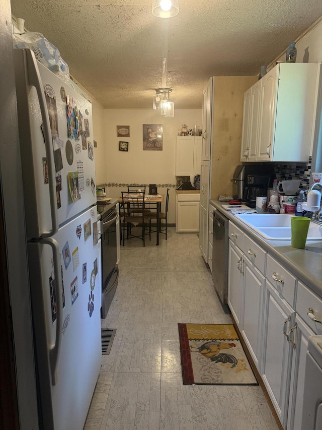 1661 W Francis Spring Rd, Whitwell, TN 37397 - kitchen with freestanding refrigerator, range with electric stovetop, stainless steel dishwasher, a textured ceiling, and white cabinets