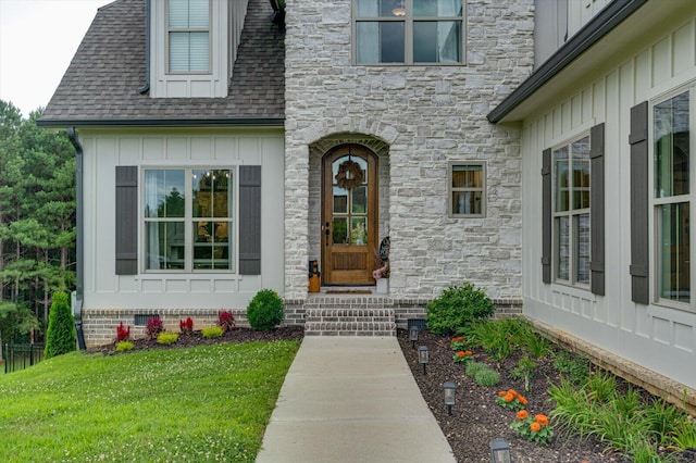 12951 Blakeslee Dr, Soddy Daisy, TN 37379 - view of exterior entry featuring board and batten siding, stone siding, a yard, and roof with shingles