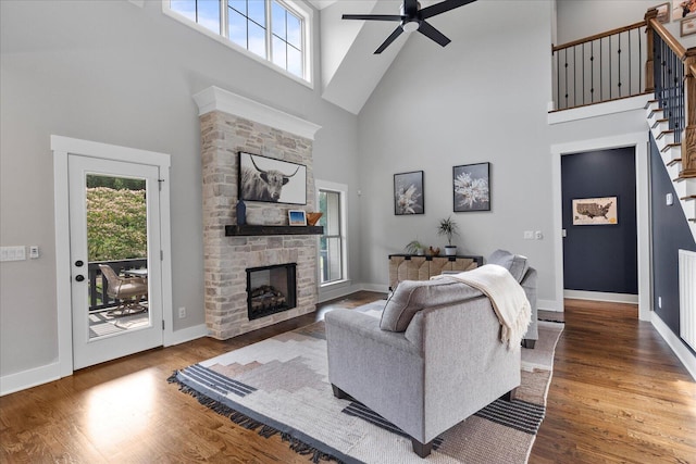 12951 Blakeslee Dr, Soddy Daisy, TN 37379 - living room featuring high vaulted ceiling, a ceiling fan, a fireplace, wood finished floors, and stairway