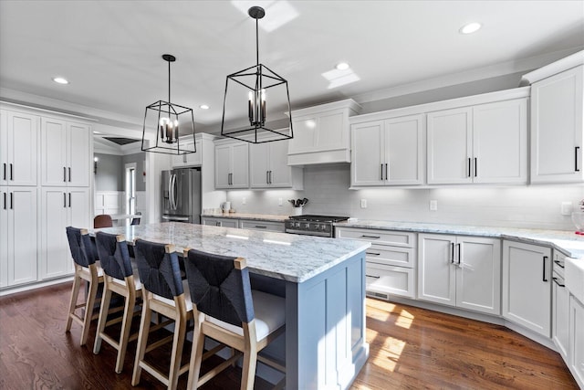 12951 Blakeslee Dr, Soddy Daisy, TN 37379 - kitchen featuring appliances with stainless steel finishes, crown molding, a chandelier, white cabinetry, and a center island