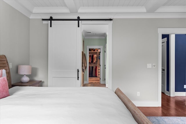 12951 Blakeslee Dr, Soddy Daisy, TN 37379 - bedroom featuring wood finished floors, beamed ceiling, a walk in closet, a barn door, and crown molding