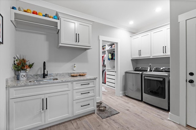 12951 Blakeslee Dr, Soddy Daisy, TN 37379 - laundry room with independent washer and dryer, cabinet space, light wood-style flooring, recessed lighting, and bar with sink