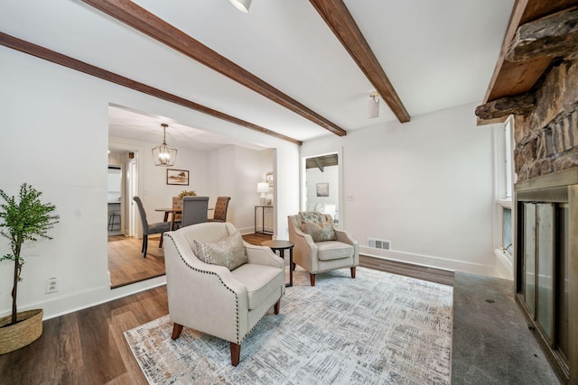 507 Big Stump Mountain Trl, Jasper, GA 30143 - sitting room featuring wood finished floors, beamed ceiling, a large fireplace, and a chandelier