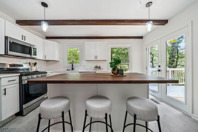 507 Big Stump Mountain Trl, Jasper, GA 30143 - kitchen with wood counters, appliances with stainless steel finishes, beamed ceiling, tasteful backsplash, and white cabinetry