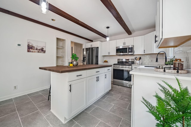 507 Big Stump Mountain Trl, Jasper, GA 30143 - kitchen featuring appliances with stainless steel finishes, butcher block countertops, decorative backsplash, white cabinetry, and beam ceiling