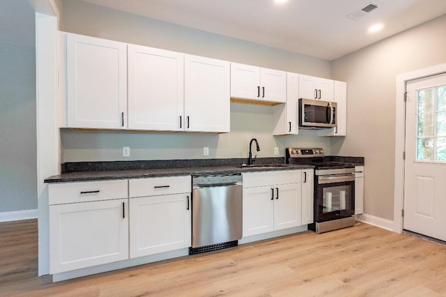 409 Hall St, Lafayette, GA 30728 - kitchen featuring stainless steel appliances, white cabinets, light wood-type flooring, and recessed lighting