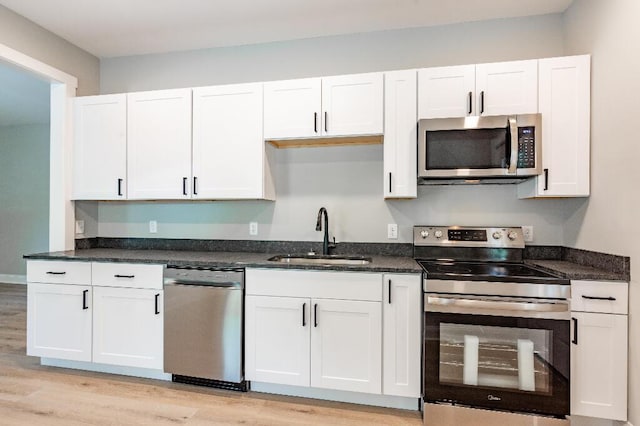 409 Hall St, Lafayette, GA 30728 - kitchen featuring appliances with stainless steel finishes, light wood-style flooring, and white cabinets