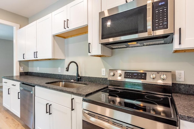 409 Hall St, Lafayette, GA 30728 - kitchen featuring appliances with stainless steel finishes, white cabinets, dark stone countertops, and light wood-style flooring