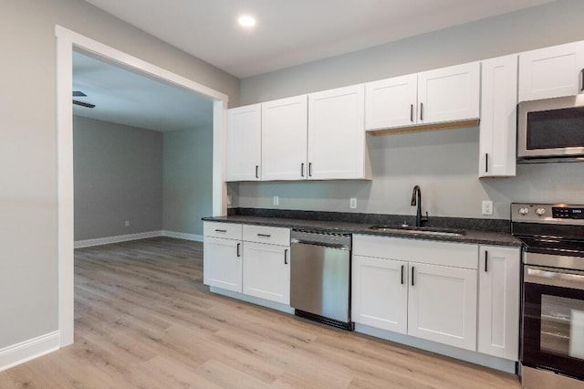 409 Hall St, Lafayette, GA 30728 - kitchen featuring appliances with stainless steel finishes, light wood-style floors, white cabinets, and dark stone counters