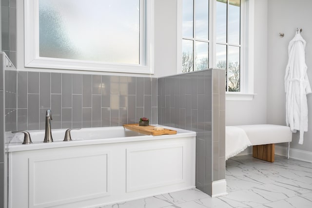 147 Honeycomb Ln, Chattanooga, TN 37421 - bathroom featuring marble look tiles, a bath, and tasteful backsplash