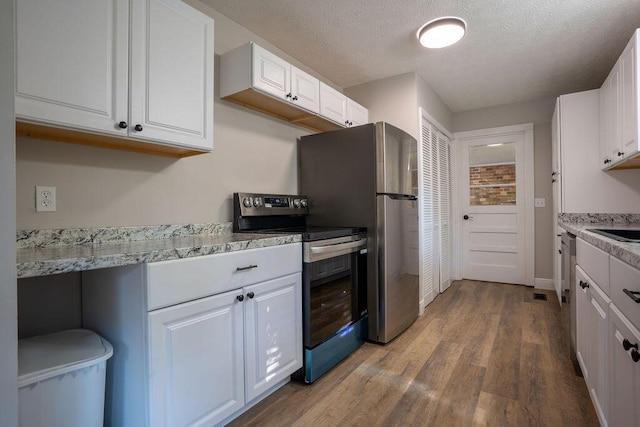 316 Old Hales Gap Rd, Trenton, GA 30752 - kitchen featuring appliances with stainless steel finishes, wood finished floors, white cabinetry, and a textured ceiling