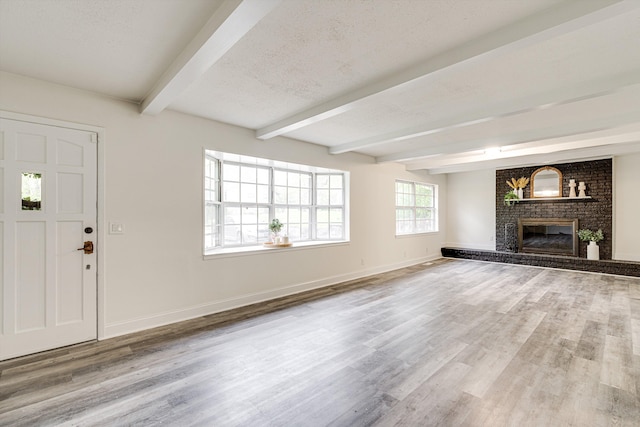 3706 Altamira Dr, Chattanooga, TN 37412 - unfurnished living room featuring beamed ceiling, wood finished floors, a brick fireplace, and a textured ceiling