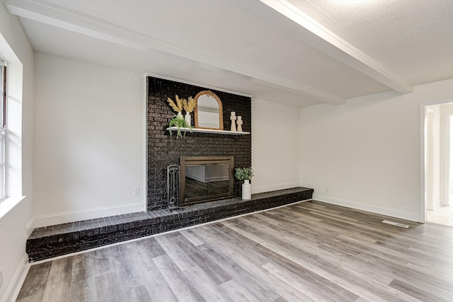 3706 Altamira Dr, Chattanooga, TN 37412 - unfurnished living room with wood finished floors, beamed ceiling, and a brick fireplace