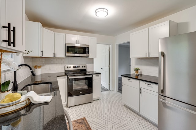 3706 Altamira Dr, Chattanooga, TN 37412 - kitchen with appliances with stainless steel finishes, tasteful backsplash, dark stone counters, and white cabinets