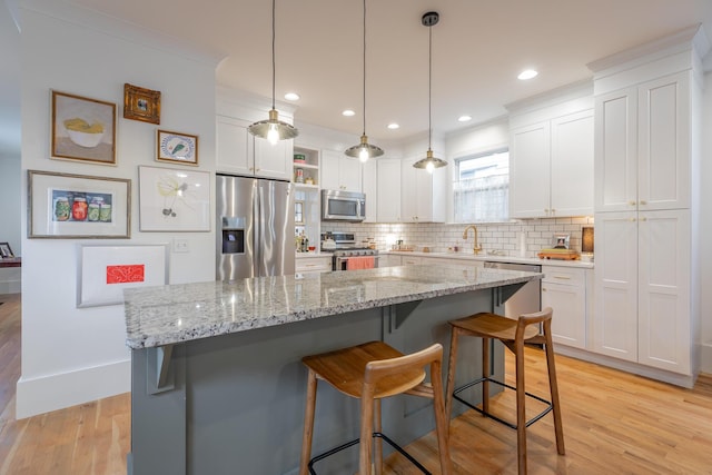 661 E 16th St, Chattanooga, TN 37408 - kitchen featuring appliances with stainless steel finishes, white cabinetry, a kitchen bar, tasteful backsplash, and recessed lighting