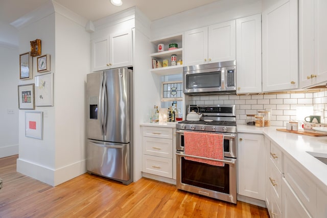 661 E 16th St, Chattanooga, TN 37408 - kitchen with appliances with stainless steel finishes, light wood-type flooring, light countertops, tasteful backsplash, and recessed lighting