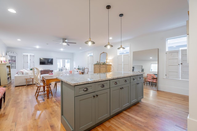 661 E 16th St, Chattanooga, TN 37408 - kitchen featuring gray cabinetry, ceiling fan, a kitchen island, light wood finished floors, and light stone counters