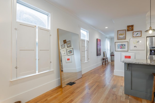 661 E 16th St, Chattanooga, TN 37408 - kitchen with stainless steel refrigerator with ice dispenser, light wood-style floors, ornamental molding, light stone counters, and recessed lighting