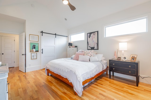 661 E 16th St, Chattanooga, TN 37408 - bedroom featuring a barn door, light wood finished floors, high vaulted ceiling, and a ceiling fan