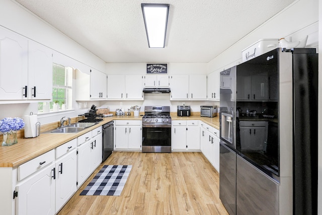 176 Ola Dr, Cohutta, GA 30710 - kitchen featuring black appliances, a textured ceiling, light wood finished floors, white cabinetry, and light countertops