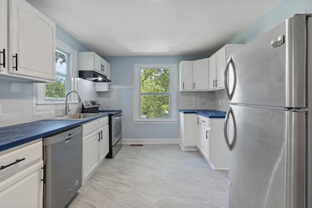 3018 14th Ave, Chattanooga, TN 37407 - kitchen featuring stainless steel appliances, dark countertops, under cabinet range hood, and white cabinets