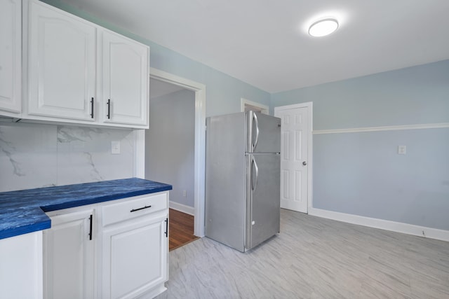 3018 14th Ave, Chattanooga, TN 37407 - kitchen featuring freestanding refrigerator, dark countertops, decorative backsplash, white cabinetry, and light wood-style floors